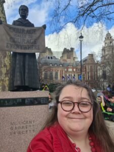 Amber Marshall (Big Birthas) stood in front of the statue of Millicent Garrett Fawcett in Parliament Square.