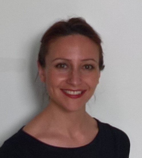 Picture of a smiling Layla against a white wall.