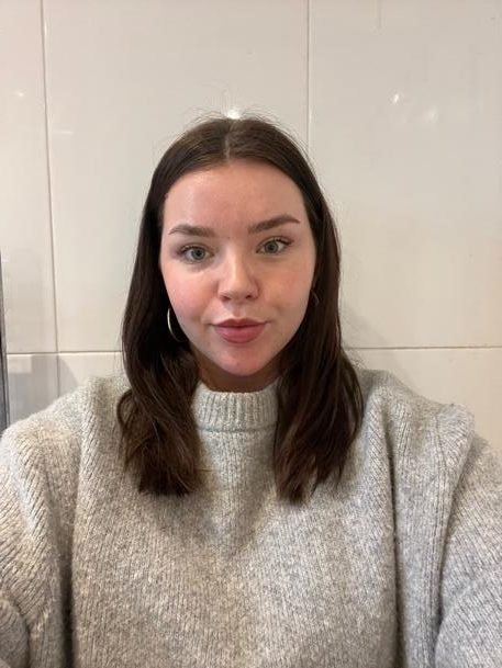Picture of Lucy Dixon, who has shoulder length brown hair, and is smiling at the camera
